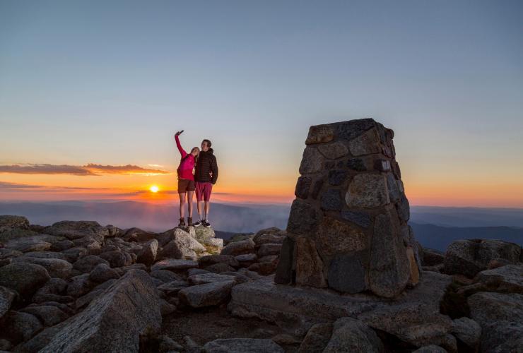 Ein Pärchen macht ein Selfie auf dem Gipfel des Mount Kosciuszko im Kosciuszko National Park, New South Wales © Tourism Snowy Mountains