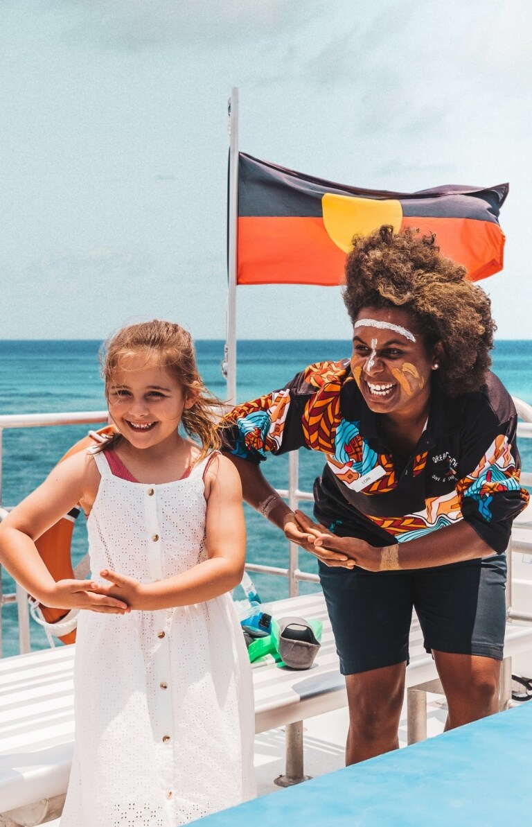 Kinder, die auf einer Tour mit Dreamtime Dive and Snorkel mit einem Aboriginal Guide für ein Foto posieren Kinder, die auf einer Tour mit Dreamtime Dive and Snorkel mit einem Aboriginal Guide für ein Foto posieren