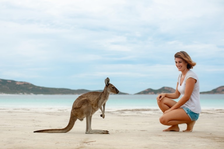 Woman admires a kangaroo on a white sand beach at Lucky Bay, Esperance, Western Australia © Tourism Australia Woman admires a kangaroo on a white sand beach at Lucky Bay, Esperance, Western Australia © Tourism Australia