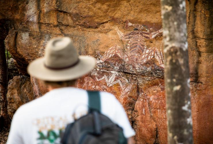 A visitor gazes at a wall of ancient rock art in Kakadu National Park, Northern Territory © Tourism NT
