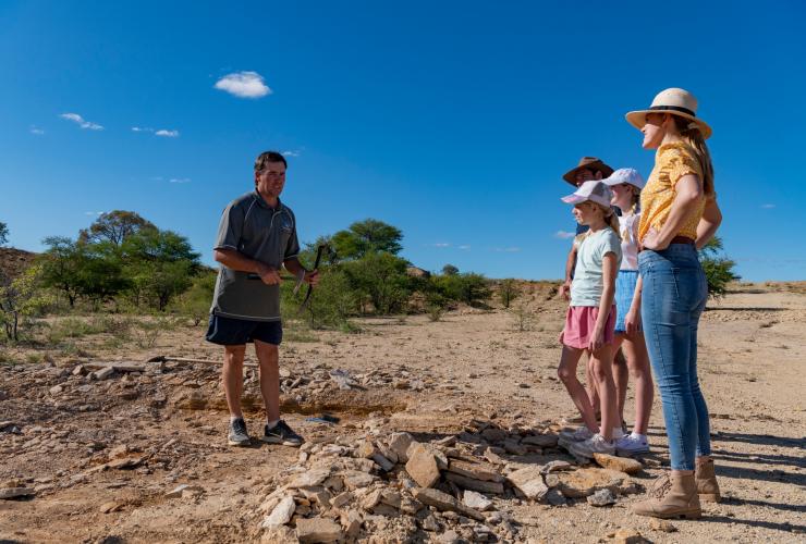 A guide points out fossils in the dirt at Kronosaurus Korner, Richmond, Queensland © Tourism and Events Queensland