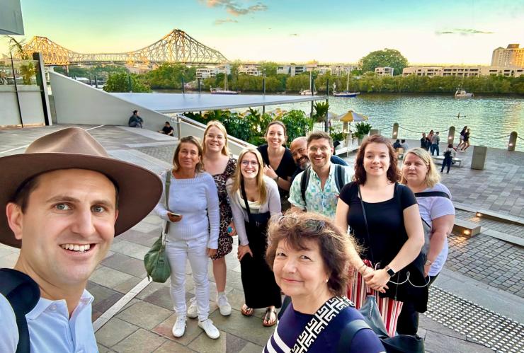 A tour guide taking a selfie with a group of people in front of a river running through a city during a tour with Urban Tours, Brisbane, Queensland © Urban Tours