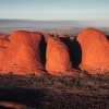 A large red rock monolith rising from the flat outback landscape at Uluru, Uluru-Kata Tjuta National Park, Northern Territory © Tourism Australia