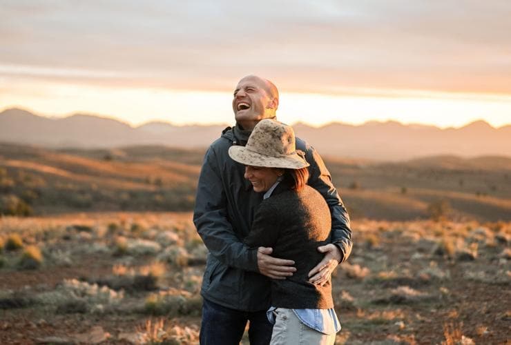 Una coppia sorridente abbracciata a Blinman, Flinders Ranges, South Australia © Tourism Australia
